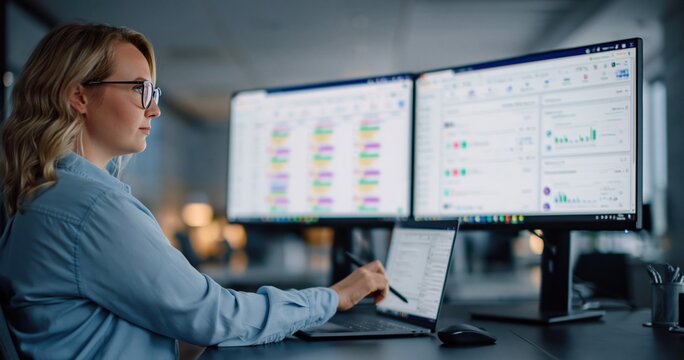 Data analysis and business intelligence woman working with charts and graphs on multiple computer screens analyzing. High quality photo