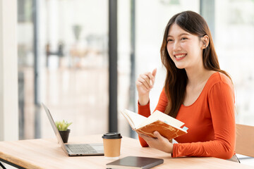 Obraz premium Successful Asian Businesswoman Smiling with New Ideas in Modern Cafe
