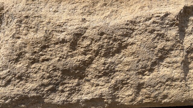 Rough grunge brown sandstone block texture background with natural cracked rocky surface for construction