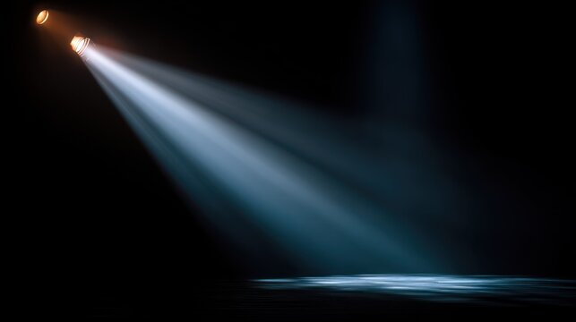 Bright theatrical illumination cuts through dense darkness from overhead fixtures