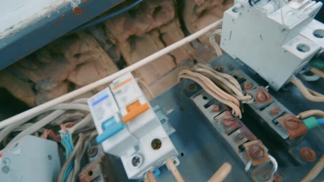 New Circuit Breakers and Relay Installed in Old Rusty Electrical Panel | Dutch Angle Close-Up of Modern Fuse Box with Wiring | Home Electrical Renovation