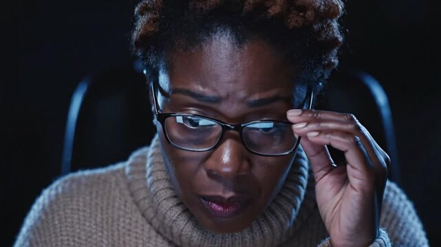 Close up of woman with glasses using computer software for VSRExport in dark room