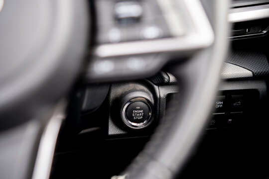 Close-up of a right-hand drive (RHD) vehicle interior  of a modern vehicle dashboard focusing on a circular engine start-stop ignition button in Australia