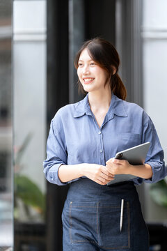 Smiling Young Asian Businesswoman with Tablet