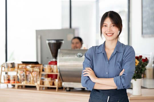 Portrait of a smiling young Asian female cafe owner
