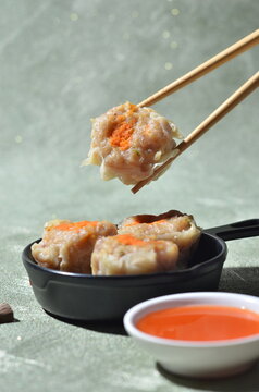 Tasty cut of siomay dumplings with chopsticks, Indonesian style dish.
