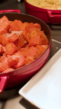 Serving Roasted Carrots from a Red Pot at a Luxury Buffet