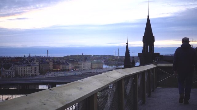 Stockholm, Sweden A man walks on the Monteliusvagen landmark walkway in the Sodermalm district with a view over the Old Town, or Gamla Stan.  