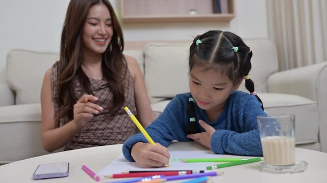 Asian mother and daughter drawing together and giving high five