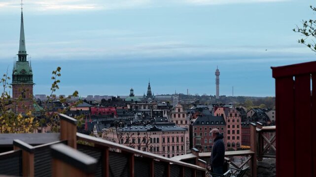 Stockholm, Sweden A man walks on the Monteliusvagen landmark walkway in the Sodermalm district with a view over the Old Town, or Gamla Stan.