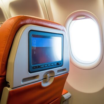 Airplane seat with inflight entertainment screen and window view