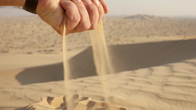 Slow Motion Sand Falling Through Man's Fingers with Watch, Cinematic Close-Up in Rub' al Khali Desert Oman