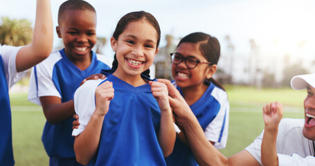 Obraz premium Football field, team and girl with smile for win, laughing or celebration for challenge achievement. Soccer, coach and cheering for success with kids, skill development and happiness after match