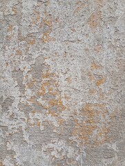 Fototapeta premium Old concrete wall, damaged, uneven structure, with remnants of yellow paint, vintage background for design