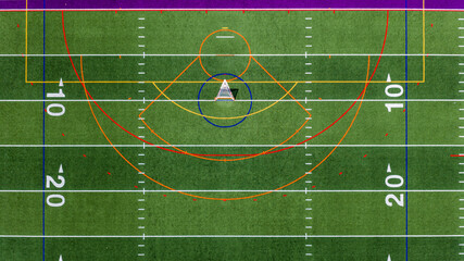 Aerial view of a multi-purpose athletic turf field featuring a lacrosse goal within a blue circular crease and overlapping colored lines for different sports.  Lacrosse, Soccer, Field Hockey, Football © Thomas