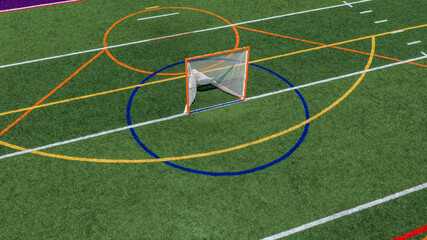 Aerial view of a multi-purpose athletic turf field featuring a lacrosse goal within a blue circular crease and overlapping colored lines for different sports.  Lacrosse, Soccer, Field Hockey, Football © Thomas