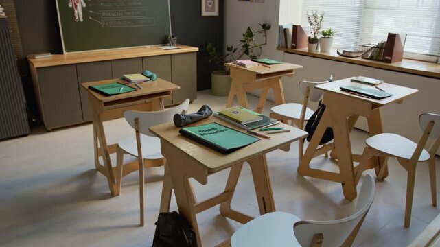 Full no people establishing shot of classroom at middle or high school, featuring student desks, with health education textbook, notebooks, pens, human anatomy diagram on blackboard before lesson