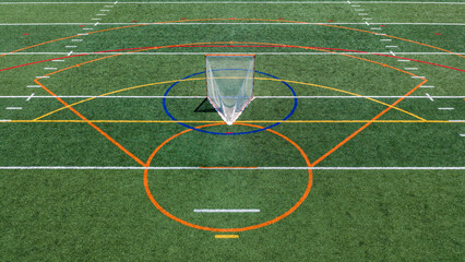 Aerial view of a multi-purpose athletic turf field featuring a lacrosse goal within a blue circular crease and overlapping colored lines for different sports.  Lacrosse, Soccer, Field Hockey, Football © Thomas
