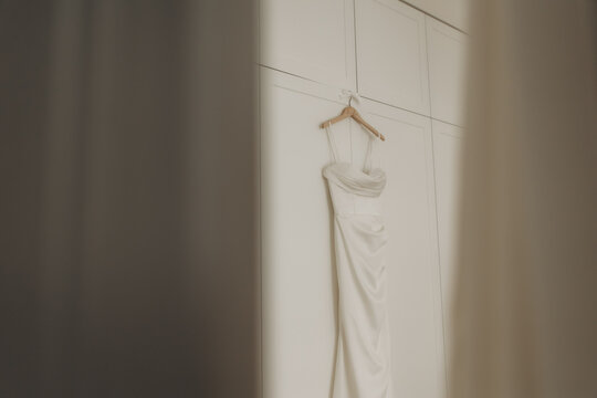 Bridal wedding dress hanging on white closet for event