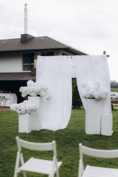 Outdoor wedding ceremony arch with white flowers