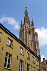 Fototapeta premium Bruges, case, strade e canali nella città delle e Bruges, la torre campanaria della Chiesa di Nostra Signora , Fiandre, Belgio
