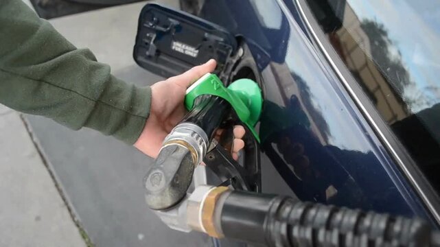 close up Hand holding faucet atomizer for refueling Process of car refilling, close up. Filling car with gas fuel at station pump LPG pump gun economy