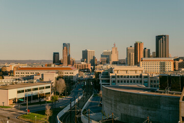 Obraz premium Minneapolis skyline with downtown buildings and roads during sunset.