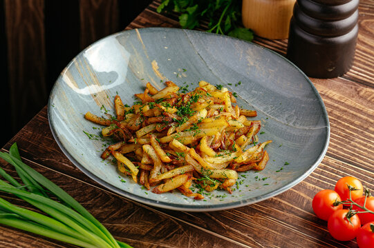 fried potatoes with herbs in a plate on the table