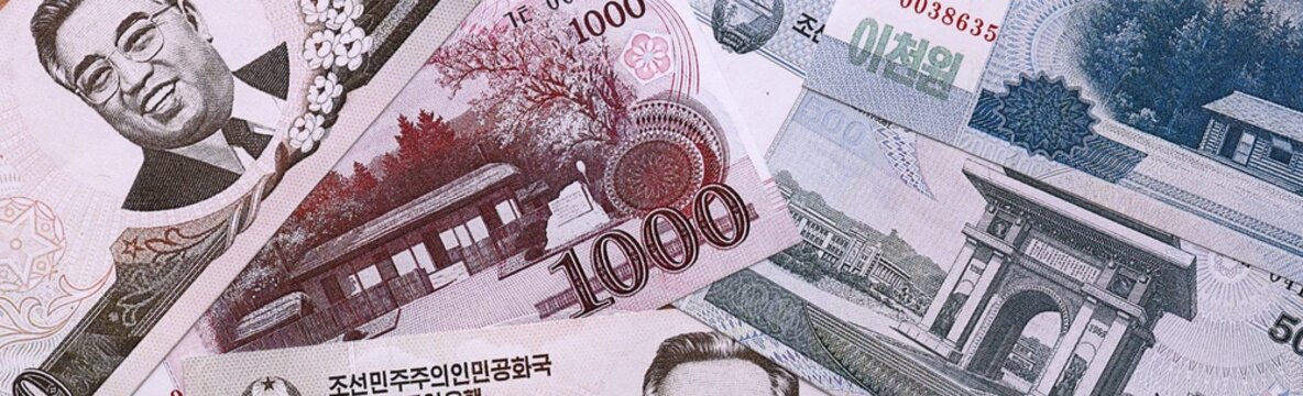 North Korean won money bills pile on table. North Korea banknotes of KPW currency close up.