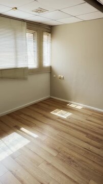 UGC style vertical phone reel of empty office floor in building with wooden parquet flooring. Vacant lot of closed bankrupt business foreclosure or new modern start up moving indoors. POV social
