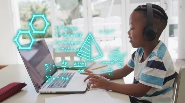 Boy sitting at laptop typing and speaking causing neon hexagons covering hands aiding learning