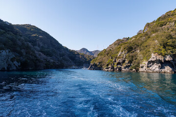 Obraz premium 港の奇岩。伊豆半島の先端、静岡県賀茂郡南伊豆町の石廊崎から出発する岬めぐり遊覧船マリンバード号。 おしどりの形の素敵な船。 石廊崎灯台やシュノーケリングスポットで有名なヒリゾ浜や大根島、大瀬の蓑掛岩などを遊覧できる。 日本国静岡賀茂郡南伊豆町石廊崎-2025/
