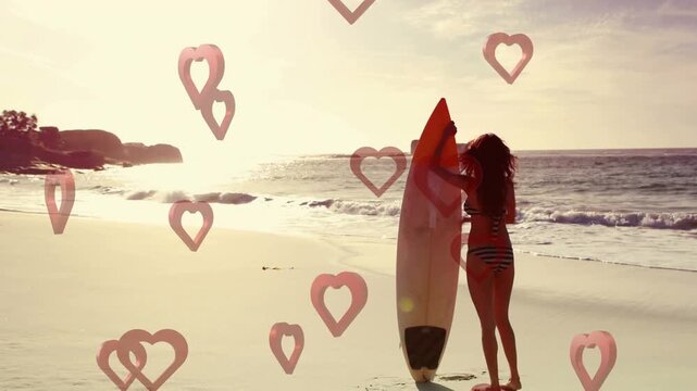 Woman entering right, placing surfboard and preparing to surf, pink hearts over subject for travel