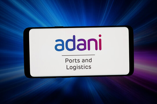 Stuttgart, Germany - 04-23-2026: In this photo illustration, the logo of Adani Ports and Special Economic Zone Limited is displayed on a smartphone in front of abstract background on computer screen.