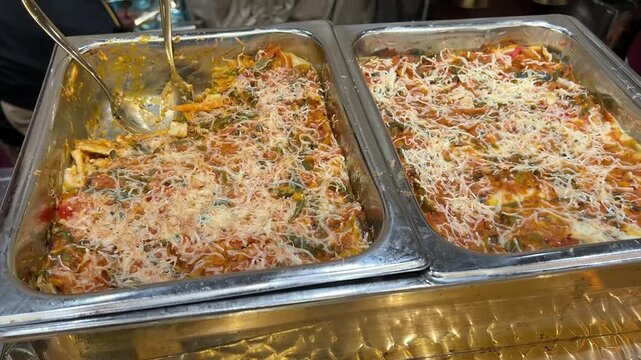 A large catering tray of vegetable au gratin, featuring garden-fresh vegetables baked in a rich, creamy b&eacute;chamel sauce with a perfectly melted cheese crust.