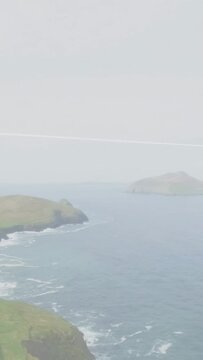 Vertical video: Camera starting slow pan, cliff and sea shifting, dark band crossing revealing sea