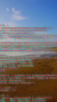 Vertical video: Glitching code causing panning, sandy shore and surf revealing cape to reveal coast