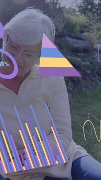 Vertical video: Senior woman reading book sparking AR data rings changing bars rising for education