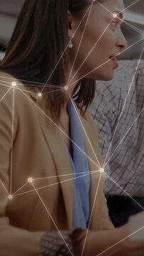 Vertical video: Woman hearing peer quip at work, turning, gesturing, laughing with net overlay