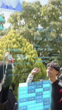 Vertical video: Grads raising diplomas celebrating on lawn initiating AR econ HUD overlaying scene