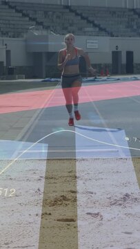 Vertical video: Woman runner running planting board jumping landing sand track metrics HUD updating