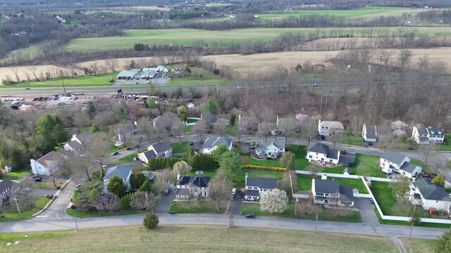 Curved street housing block forms compact residential pocket near Old York Rd, US 202 corridor in Readington Township. Repeating rooflines, blooming trees color shifts, Three Bridges, New Jersey