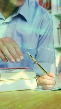 Vertical video: Adult male reaching, guiding child's yellow pencil on notebook for writing lesson