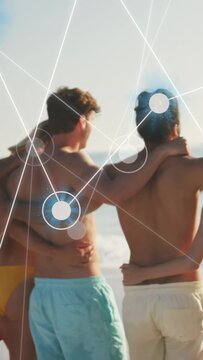 Vertical video: friends linking arms at sea sparking glowing nodes  and  lines visualizing tech unit