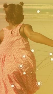 Vertical video: Girl holding man hand on beach guiding toward waves while tech hexagons overlaying