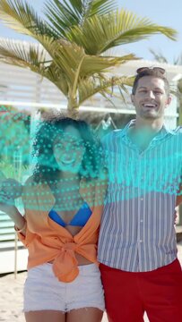 Vertical video: Couple posing at beach club while turquoise dot wave sweeping faces, for marketing