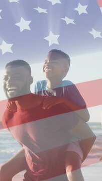 Vertical video: Father carrying son walking beach, animated flag overlay appearing for patriotic ad