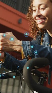 Vertical video: Woman commuting tapping phone on bike bars, AR hexagons appearing, viewing route