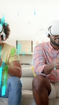 Vertical video: Two men pressing pads and activating gaming VR with green or blue bars on sofa for f