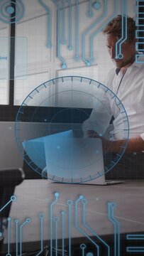 Vertical video: Man typing on laptop in business office, preparing deck while blue HUD overlaying